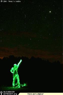 Teido de verde por la luz del flash, el astrnomo Dennis Mammana, de California, seala a Marte a espectadores, el 26 de agosto de 2003, la ltima vez que Marte se acerc tanto a la Tierra. 
<i>Crdito de la foto: Thad VSoske.</i>

