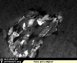 Pequeo fragmento del mineral olivino, uno de los granos de polvo de cometa embebido en el aerogel en la misin Stardust. 
Crdito: NASA