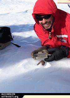 Encontrar un meteorito en la Antártida. Cuando los meteoritos adquieren una costra negra de fusión resaltan visualmente en los blancos campos de hielo. Crédito: ANSMET.