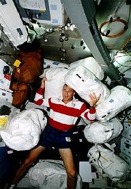 El piloto del transbordador Terry Wilcutt con 7 depsitos de contingencia destinados a la estacin espacial Mir