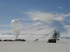 El telescopio BOOMERANG cuando era preparado para su lanzamiento.  Con el Monte Erebus como teln de fondo, el personal de NASA/NSBF infla el globo de un milln de m3 (28 millones de pies cbicos) que transportar el telescopio BOOMERANG en el viaje de 10 das alrededor del continente Antrtico.  Para poder obtener sus medidas exquisitamente sensibles, el BOOMERANG es elevado por encima del 99% de la atmsfera hasta una altura de 35 km (120000 pies).  La luz continua del sol y las corrientes de aire estables sobre la Antrtica, posibilitan los vuelos estratosfricos largos de globo con una duracin de 10 a 20 das.  Este lanzamiento fue precedido por 2 meses de ensamble en la estacin de Investigacin de McMurdo y un lustro de desarrollo y construccin por parte de un equipo internacional de investigadores [<A HREF= http://www.physics.ucsb.edu/~boomerang/press_images/index.html target=_blank>Ms imgenes</A>]