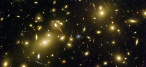 La imagen de Abel 2218 captada por el Telescopio Espacial Hubble. Este cúmulo masivo de galaxias reside en la constelación Dragón, a una distancia de 2000 millones de años luz de la Tierra. Los arcos son imágenes de galaxias muy lejanas que han sido torcidas por el efecto del lente gravitacional, situadas por detrás del cúmulo, a grandes distancias.