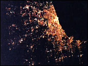 El agua negra del Lago Michigan en el lmite de las luces brillantes de Chicago, cuyo color se pierde en el paisaje rural de la izquierda. Los cientficos de la NASA recopilan el juego de luces detectadas desde el espacio para medir la extensin de las ciudades y las reas urbanas en todo el mundo.