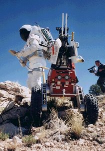 El Asistente Robtico de Actividad Extra Vehicular de la NASA a la par de un traje de astronauta. Este par son verdaderos compaeros en la exploracin. <A HREF= http://vesuvius.jsc.nasa.gov/er_er/html/era/ERA_Home_Page.html>[ms]</A>