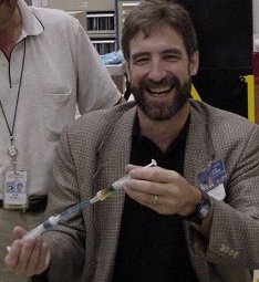 El Profesor Pojman muestra el prototipo de experimento MFMG. Bob Powell, un experto de la NASA en el desarrollo de procedimientos para experimentos en microgravedad, mira sobre su hombro. Imagen cortesía de la NASA.