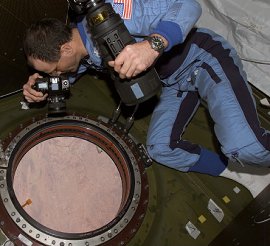 El astronauta Don Pettit, oficial cientfico de la Expedicin Seis ISS, toma fotografas de la Tierra a travs de la ventana del laboratorio Destiny en la Estacin Espacial Internacional (ISS). <A HREF= http://eol.jsc.nasa.gov/scripts/sseop/photo.pl?mission=ISS006&roll=E&frame=18372&QueryResultsFile=1048138731408.tsv target=_blank>[ms]</A>