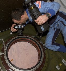 El oficial cientfico de la estacin espacial <A HREF= http://www.spaceflight.nasa.gov/station/crew/exp6/spacechronicles.html targetr=_blank>Don Pettit</A> mira hacia abajo La Tierra a travs de la ventana del Laboratorio Destiny.