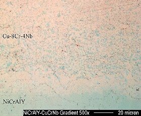 Esta vista microscópica del corte transversal del borde del recubrimiento del cono nos muestra la transición gradual de la deposición creada por la técnica de plasma al vacío.