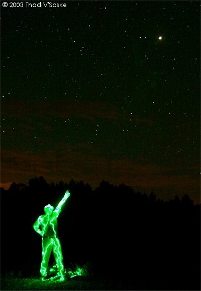 Teido de verde por la luz del flash, el astrnomo Dennis Mammana, de California, seala a Marte a espectadores, el 26 de agosto de 2003, la ltima vez que Marte se acerc tanto a la Tierra. 
<i>Crdito de la foto: Thad VSoske.</i>
